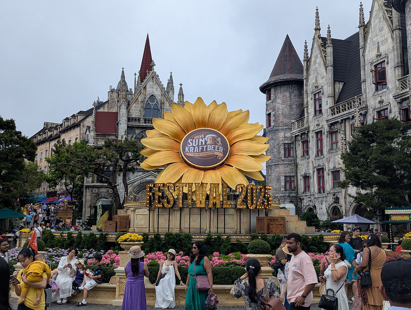 ヨーロッパ風の建物を背景に、大きなひまわりのオブジェが中央に設置されている。「SUN KRAFT BEER FESTIVAL 2025」と書かれており、多くの観光客が記念撮影を楽しんでいる。